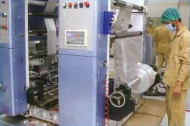 Operator running a rotogravure printing machine on aluminium foil